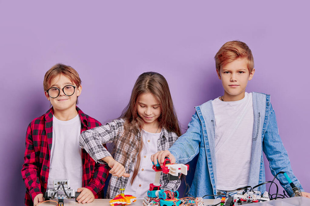 education, science, technology concept. caucasian children with electric toys and building robots - Fotó, kép