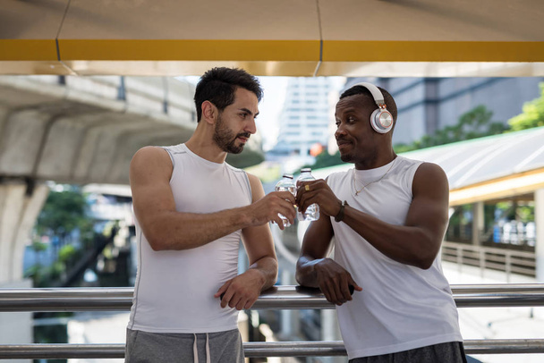 LGBT gay pareja tostadas agua después de ejercicio
 - Foto, Imagen