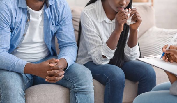 Irriconoscibile nero coppia seduta su divano a coniugale counselors ufficio
 - Foto, immagini