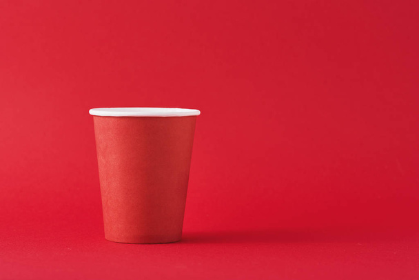 Punainen paperi kahvikuppi punaisella pohjalla ja kopiotilaa. Minimalismin tyyli
 - Valokuva, kuva