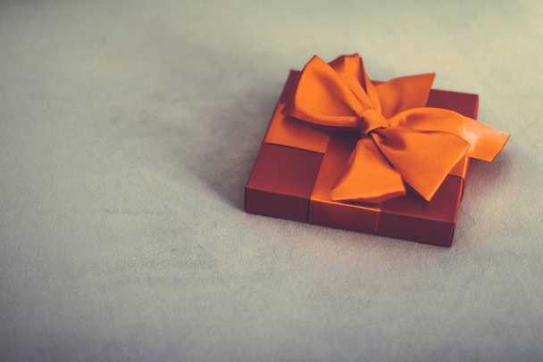 Винтажный роскошный праздник оранжевый подарочный коробок с шелковой лентой и луком
, - Фото, изображение
