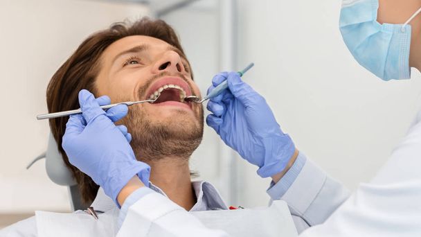 Κοντινό πλάνο του άνδρα με ανοιχτό το στόμα σε καρέκλα οδοντίατρο - Φωτογραφία, εικόνα