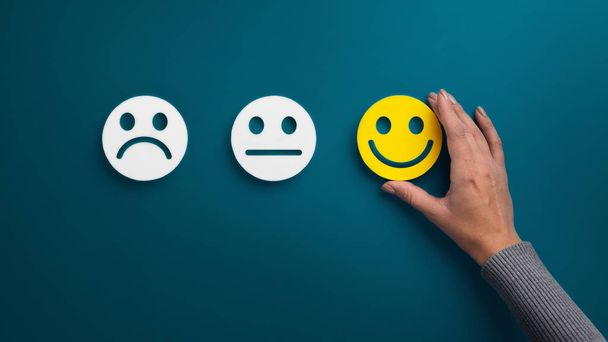 Woman choosing happy smiley face emotion on green - Photo, Image