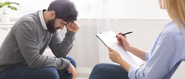 Homem milenar desesperado recebendo ajuda psicológica no terapeuta
 - Foto, Imagem