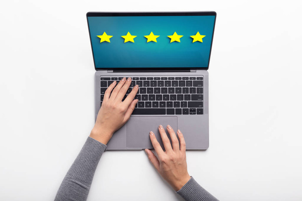 Woman using laptop with highest rating on screen - Photo, Image