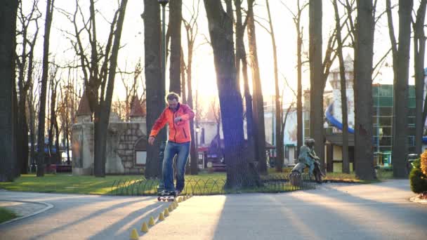 A professional roller with excellent riding technique and good stretching makes difficult turns around the cones for training in a cool autumn park. Bottom view in slow motion. Healthy life. - Footage, Video