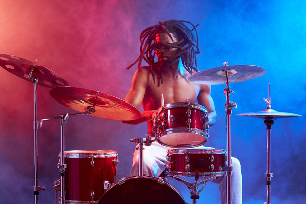 handsome attractive man showily playing on drums - Fotó, kép