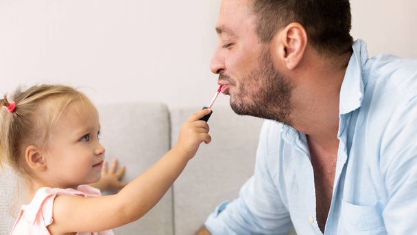Милая девушка наносит макияж на своего отца
 - Фото, изображение
