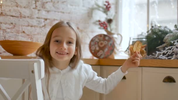 Sonriente niña rubia cubre sus ojos con rodajas de cítricos secos en casa con estilo loft y decoración de Navidad, concepto de infancia feliz
 - Metraje, vídeo