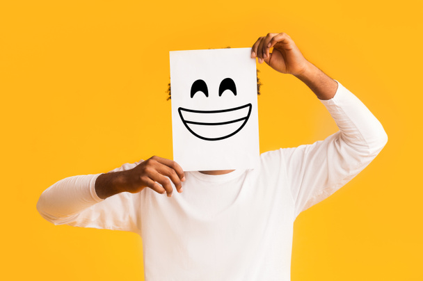 Africano americano homem segurando papel com rosto sorridente
 - Foto, Imagem