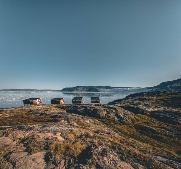 Panoramic image of Camp Eqi at Eqip Sermia Glacier in Greenland. nature landscape with lodge cabins. Midnight sun and pink sky. Tourist destination Eqi glacier in West Greenland AKA Ilulissat and - Фото, зображення