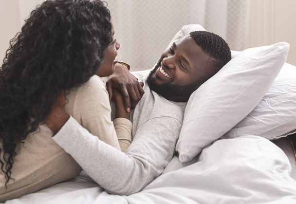 Retrato de pareja negra romántica pasando tiempo en la cama juntos
 - Foto, imagen