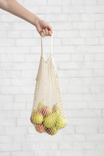Female hand holding organic pears in zero waste net bag - Fotó, kép