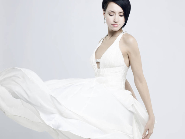 Fashionable photo of beautiful young woman in billowing white dress - Foto, afbeelding