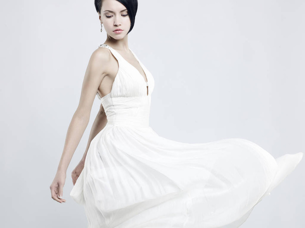 Fashionable photo of beautiful young woman in billowing white dress - Fotó, kép