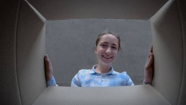 Ευτυχισμένη γυναίκα άνοιγμα χαρτονένιο κουτί με δώρο και κοιτάζοντας μέσα - έννοια των διακοπών - Φωτογραφία, εικόνα