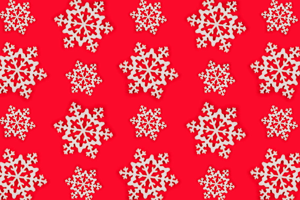 Muster aus weißen Schneeflocken über rotem festlichem Hintergrund. - Foto, Bild