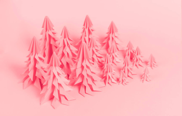 Some origami paper Christmas trees on pink paper background. - Foto, immagini