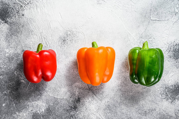 Green, orange and red bell peppers. Gray background. Top view. Space for text. - Fotografie, Obrázek