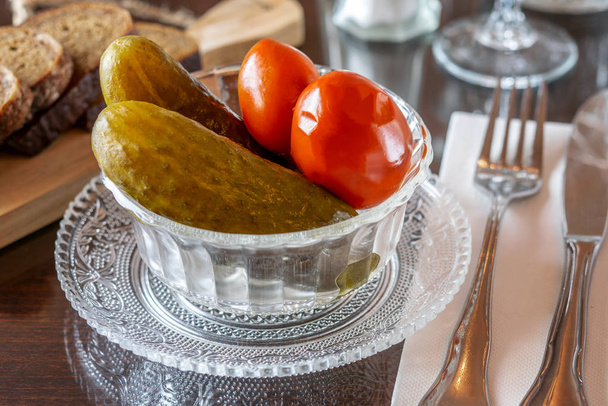 Мариновані солоні овочі огірки та помідори в склянці
  - Фото, зображення