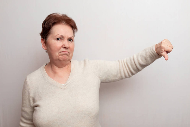 erwachsene Frau auf weißem Hintergrund in hellem Pullover. Emotionen - Foto, Bild
