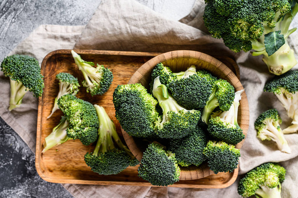 Raw broccoli in a wooden bowl. Gray background. Top view - Foto, immagini
