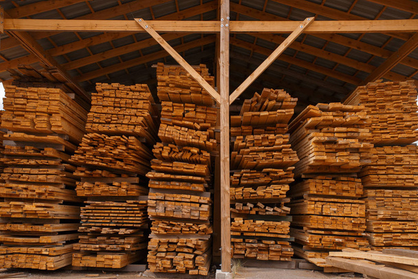 Les planches sur l'entrepôt de bois extérieur, personne, l'industrie du bois, la menuiserie. Transformation du bois en usine, sciage forestier dans la cour à bois, scierie
 - Photo, image