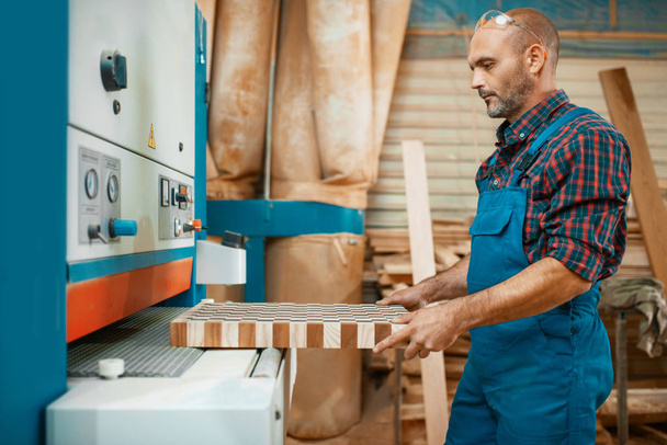カーペンターは木工機械、木材産業、大工の仕事をしています。家具工場での木材加工、天然素材の製品の生産 - 写真・画像