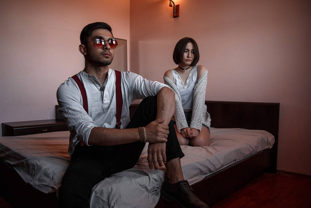 a young stylish guy in glasses and a young girl together sitting - Foto, afbeelding