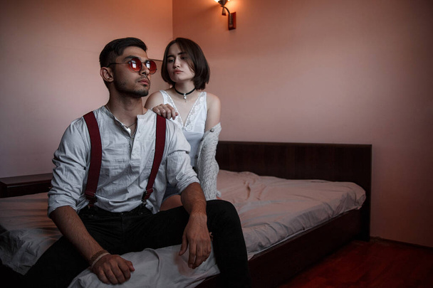 un giovane ragazzo elegante in occhiali e una giovane ragazza seduta insieme
 - Foto, immagini