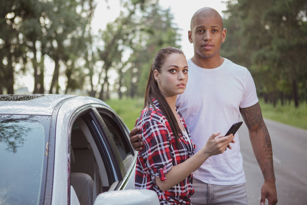 Jeune couple multiracial avec une voiture cassée au milieu de la
  - Photo, image