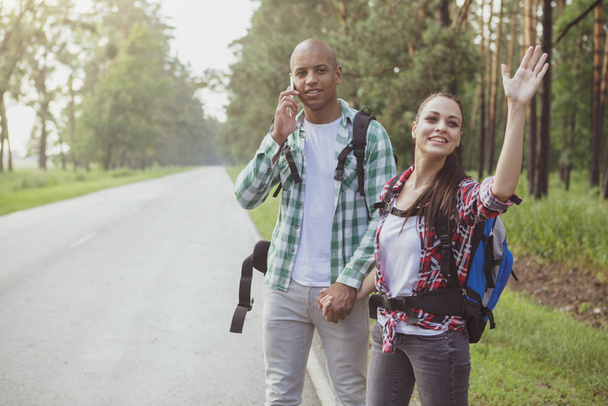 Charming multiracial couple hitchhiking together - Photo, Image