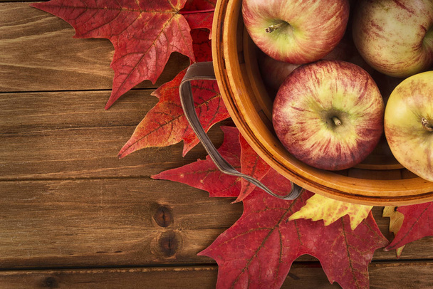Omenat kori ja vaahtera lehdet hävittää puinen pöytä. Tasainen lay, ylhäältä näkymä syksyn koristelu käsite
. - Valokuva, kuva