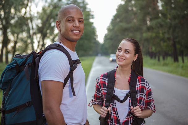 Charming multiracial couple hitchhiking together - Photo, Image