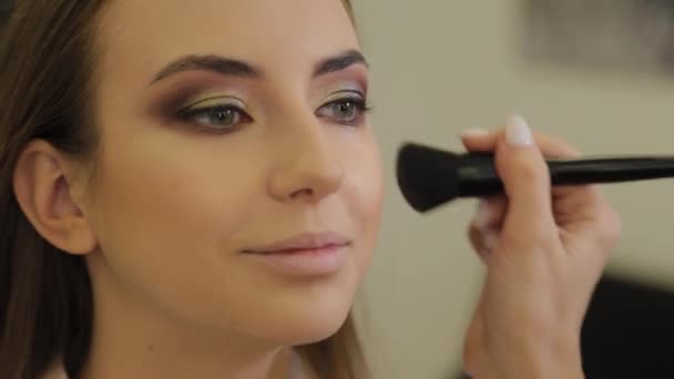 Professional makeup artist does makeup to a client of a beauty salon. - Záběry, video