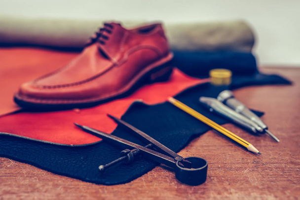 Παπούτσια maker εργαλεία και άνθρωπος κλασικό καφέ παπούτσια σε ξύλινο τραπέζι - Φωτογραφία, εικόνα