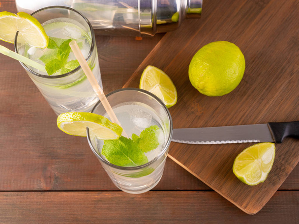 Mojito cocktail with ice, mint and lime on wooden background - Valokuva, kuva