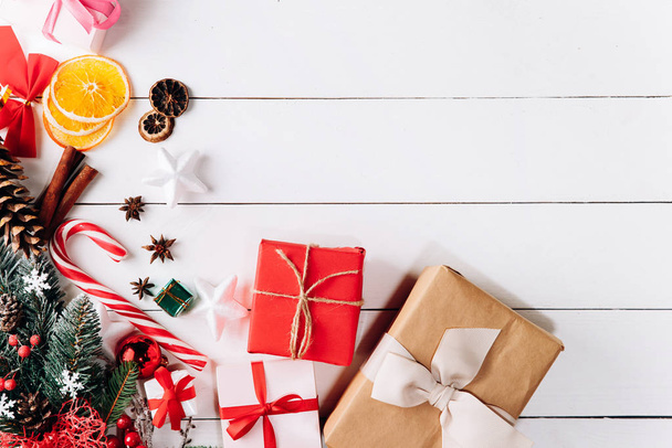 黄金のクリスマスのギフトボックス、雪のモミの枝、針葉樹のコーン、休日の装飾と白い背景に美しいクリスマスの組成。トップ表示 - 写真・画像