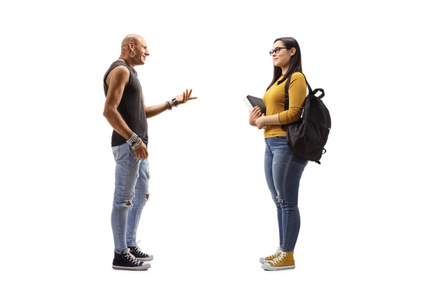Male hipster talking to a female student holding books - Foto, imagen