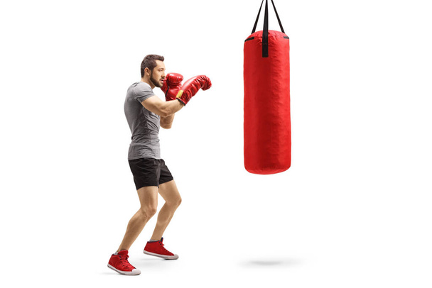 Young athlete training box with a punching bag - Fotoğraf, Görsel