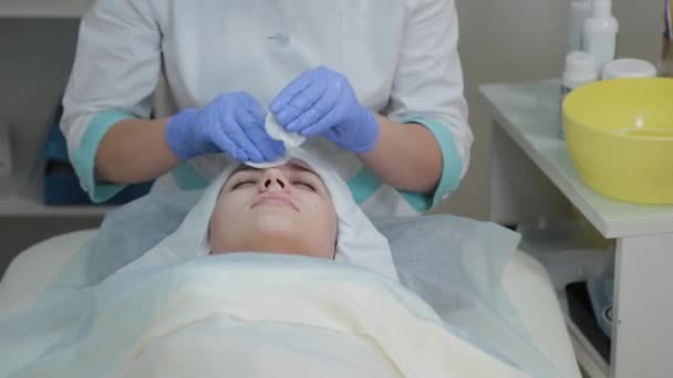 Professional beautician woman rubs her face before the procedure with wet wipes. - Footage, Video