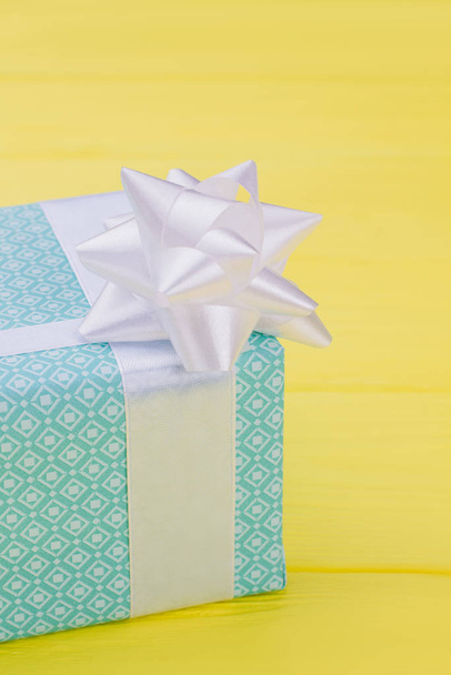 Blue gift box on yellow background. - Photo, Image