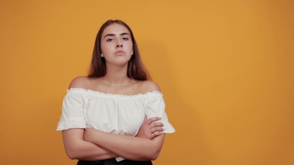 Jovem mulher séria fazendo parar, gesto de cônjuge isolado na parede laranja
 - Filmagem, Vídeo