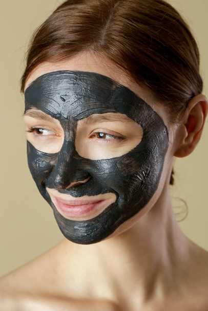 Węgiel drzewny maska twarzy lub czarny glina błoto. Piękna kobieta w czarnej masce na twarzy, ze zdjęciem w studiu. Naturalna koncepcja kosmetyczna. - Zdjęcie, obraz