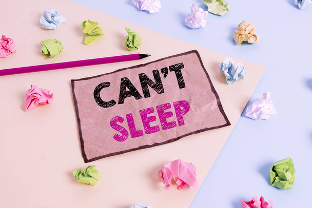 Handwriting text writing Can T Sleep. Concept meaning trouble falling asleep or wake up frequently during the night Colored crumpled papers empty reminder blue yellow background clothespin. - Photo, Image
