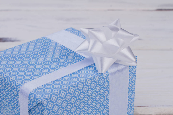 Caixa de presente azul estampada com arco branco
. - Foto, Imagem