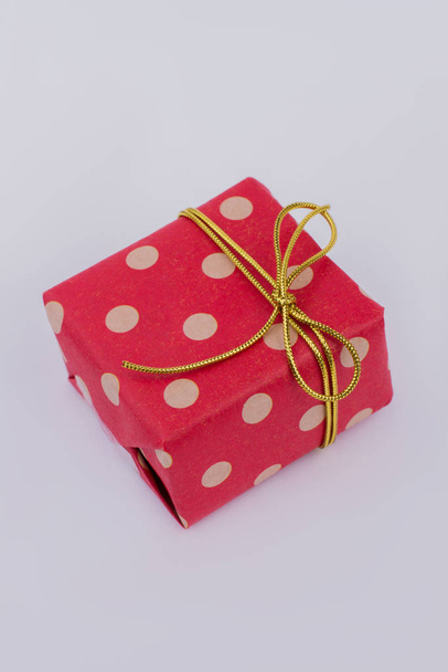 Red gift box with golden ribbon. - Fotografie, Obrázek