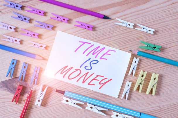 Текст для почерку Time Is Money. Концепція означає Краще робити речі якомога швидше Не затримуйте кольорові прищіпки папери порожнє нагадування про дерев'яну підлогу офіс фону
. - Фото, зображення