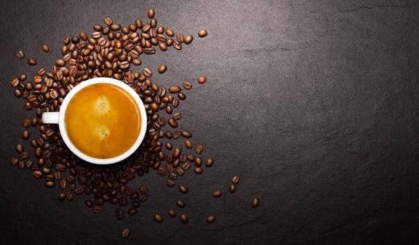 Taza de café y granos de café sobre fondo negro
 - Foto, Imagen
