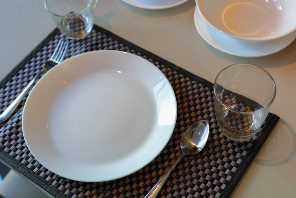 white dish ware sets arrange on dinner table inside eating room of modern home interior - Photo, Image